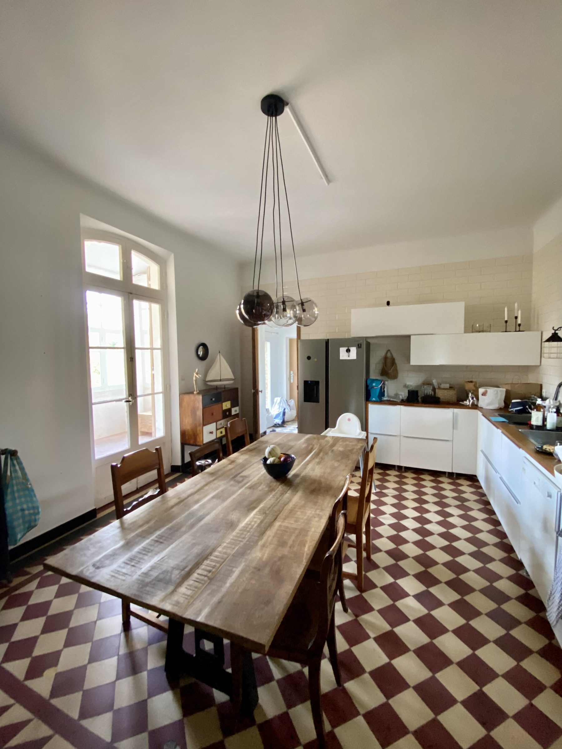 Sunlit kitchen and dining room with original checkerboard floors
